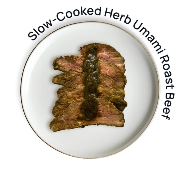 Sliced slow-cooked herb umami roast beef with a dark green sauce on a white plate.
