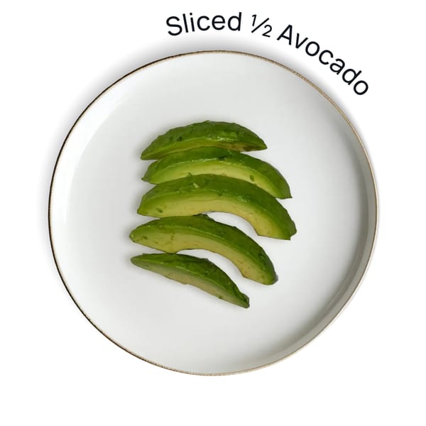 Sliced avocado on a white plate with a gold rim, against a white background.