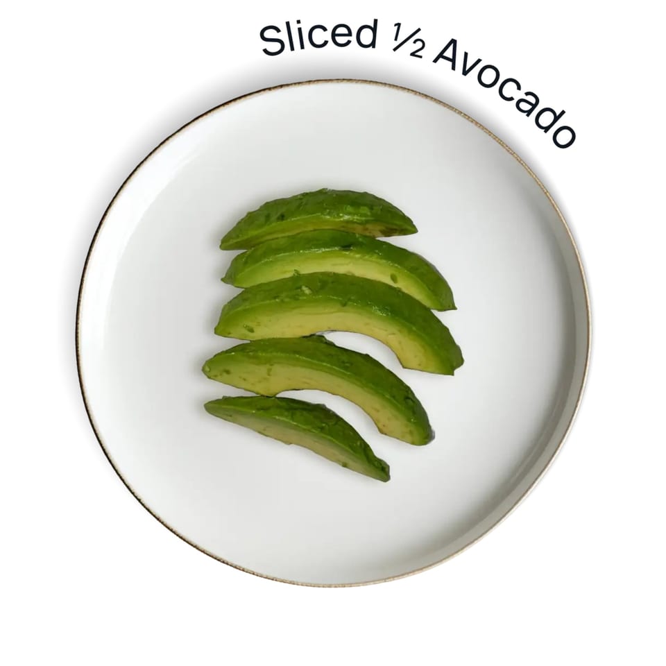 Sliced avocado on a white plate with a gold rim, against a white background.