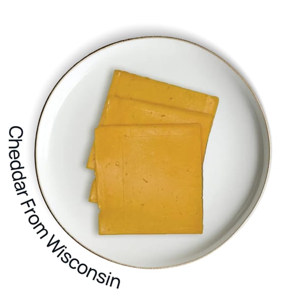 Three slices of orange cheddar cheese on a white plate with a gold rim.