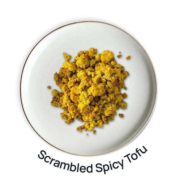 Overhead view of a white plate filled with yellow scrambled spicy tofu.